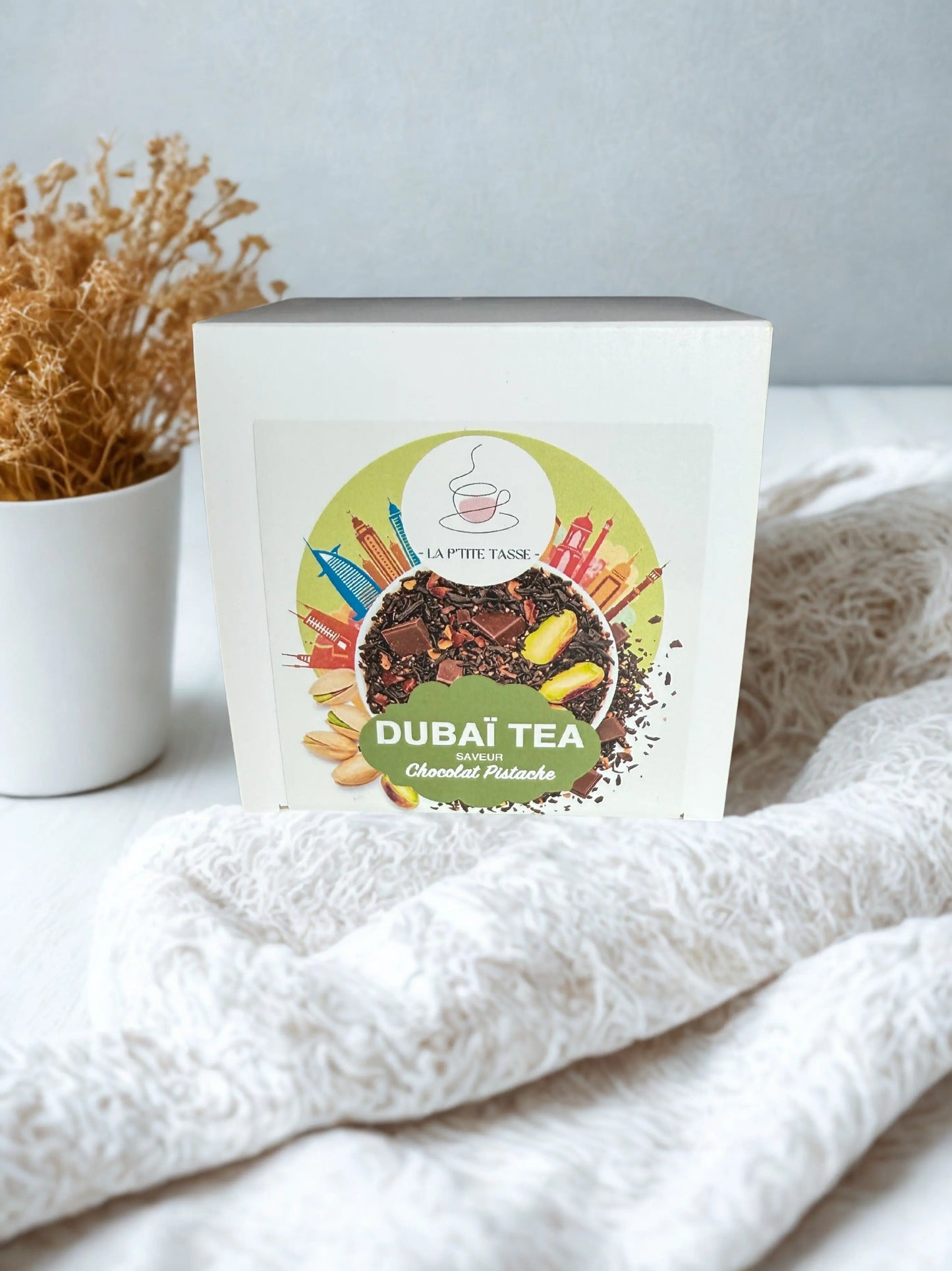 ThĂ© Dubai Tea La Pâtite Tasse â mĂ©lange aromatique et Ă©picĂ© inspirĂ© des saveurs orientales, prĂ©sentĂ© dans un emballage Ă©lĂ©gant aux touches chaleureuses.