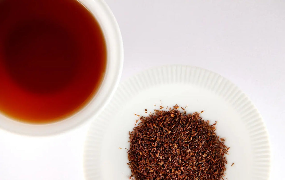 une tasse de rooibos avec le thé en évidence sur une assiette